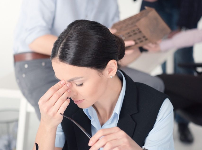 stressed-businesswoman-with-colleagues-in-backgrou-2026-03-12-22-46-11-utc – grande stressed-businesswoman-with-colleagues-in-backgrou-2026-03-12-22-46-11-utc – grande