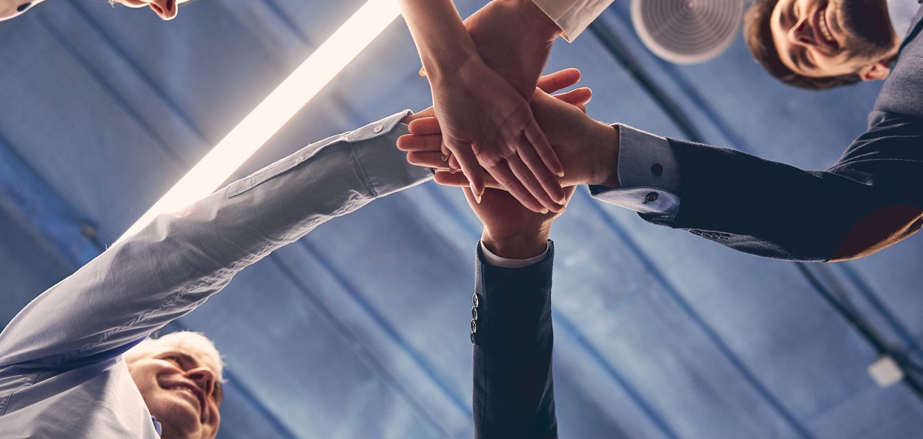 Group of executive placing their hands together Group of executive placing their hands together